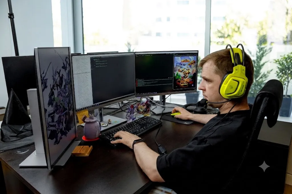 A developer testing a game build on a multi-monitor setup