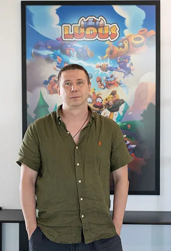 A team member in front of the LUDUS poster